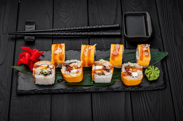 Traditional delicious fresh sushi roll set on a black background . Sushi roll with rice, cream cheese, salmon.