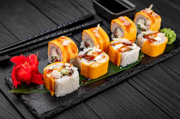 Traditional delicious fresh sushi roll set on a black background . Sushi roll with rice, cream cheese, salmon.