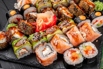 Big set of Asian food. Sushi and rolls on a dark background.