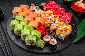 Big set of Asian food. Sushi and rolls on a dark background.