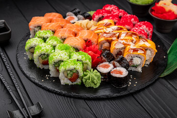 Big set of Asian food. Sushi and rolls on a dark background.