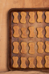 Bone shaped, homemade dog treats on a stoneware pan.