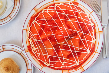 Delicious beef carpaccio in classic Cipriani style with mayonnaise sauce on a plate. Authentic Italian dish. Thin slices of raw beef. Exquisite Italian carpaccio, minimalistic food styling