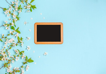 Chalk board with cherry branches on a blue background with space for text.