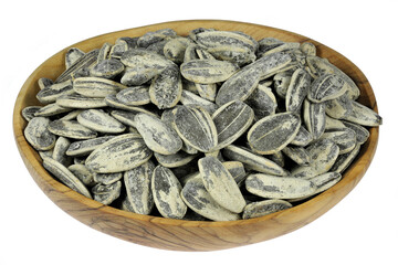 whole roasted and salted sunflower seeds in a olive wood bowl isolated on white background