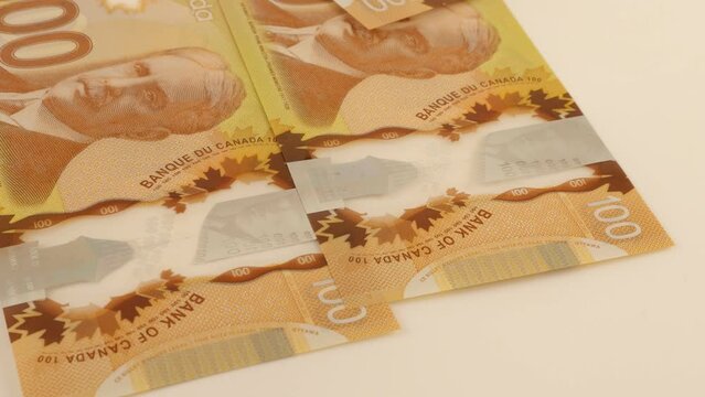 Falling Canadian 100 dollar polymer banknotes with a portrait of Robert Borden.