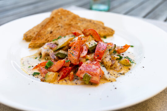 The image shows a light summer fish salad served on a rustic wooden table