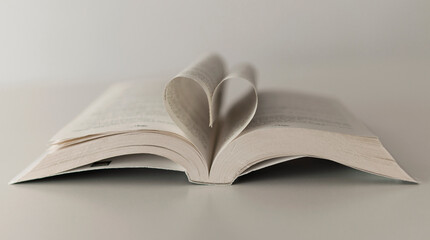 open book on a table with a heart