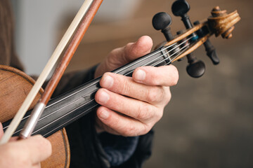 Old man playing the violin on the street, close up, street musician.