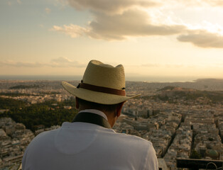 Hombre con Sombrero contempla las vistas de la Acrópolis en una puesta de Sol.