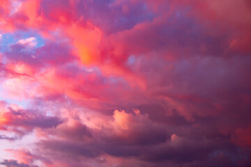 Colorful dramatic sky with pink and purple clouds before sunset. Natural sky background.
