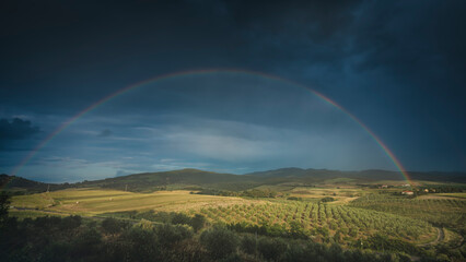 Rainbow in countryside landscape. Bibbona, Tuscany, Italy.