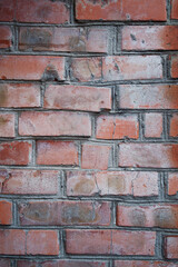 Fototapeta premium Red brick wall. City buildings. Brick background. Repair, construction. Weathered stained old brick wall background.