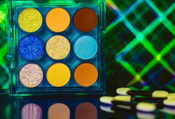 A palette of various colorful bright eyeshadows. Women's decorative cosmetics details and...