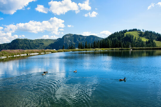 A lake in the Austrian Alps surrounded by mountains on the Grafenberg hill near the town of Wagrain.