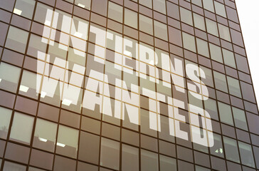 Fototapeta premium On the glass surface of the business center there is an inscription - Interns Wanted