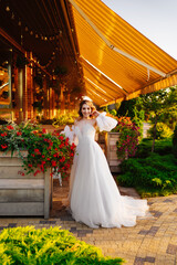 Fototapeta premium beautiful bride in a white delicate dress on the terrace of the restaurant