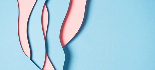 Abstract colored paper texture background. Minimal paper cut composition with layers of geometric shapes and lines in pastel pink and light blue colors. Top view, copy space