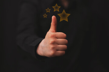 man giving an excellent rating with hand gesture, hand with thumb up, black background