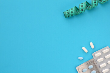 diet pills on blue background, copy space