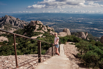 Woman hiking in Montserrat mountains in Spain alone with backpack. Traveling in Europe