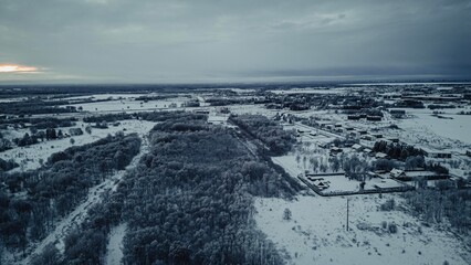 Areal picture of frozen winter suburban area and forest.