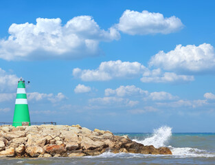 Small green lighthouse on the edge of a cliff on the Mediterranean coast of Tel Aviv, Israel