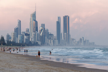Landscape of Gold Coast, city next to Brisbane in Australia, evening or morning sun on the beach, blue ocean with waves and skyscrapers. Australian holidays in summer - obrazy, fototapety, plakaty