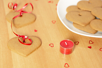 Decoration with garland of heart ginger cookies on red ribbon for a Valentines Day. 
