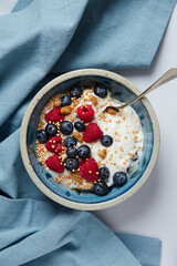 bowl wih a greek yogurt with raspberries and blueberries and mulberries