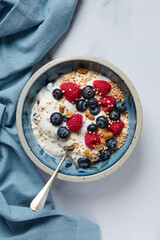 bowl wih a greek yogurt with raspberries and blueberries and mulberries