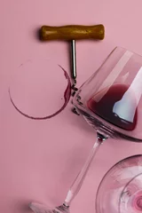 Foto op Aluminium Glasses of red wine and corkscrew on pink background, with copy space © vectorfusionart