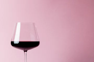 Muurstickers Glass of red wine on pink background, with copy space © vectorfusionart