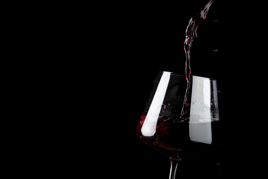 Glass of red wine on black background, with copy space