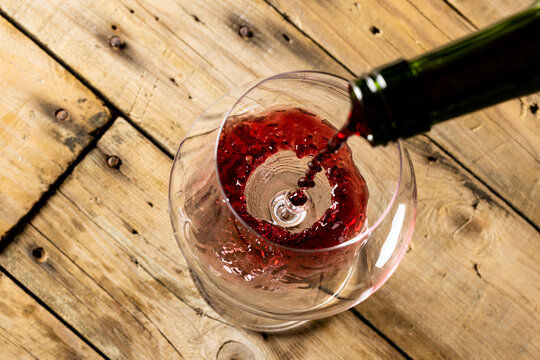 Bottle of red wine and glass on wooden background, with copy space