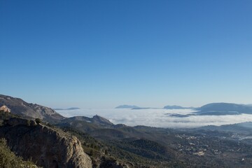 Obraz na płótnie Canvas Comarcas del Alcoia Comtat y la Safor al fondo vistas desde el Alt de les Pedreres en Alcoy con niebla espesa y cielo completamente azul