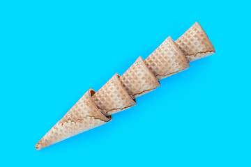 Empty ice cream cone on blue background.