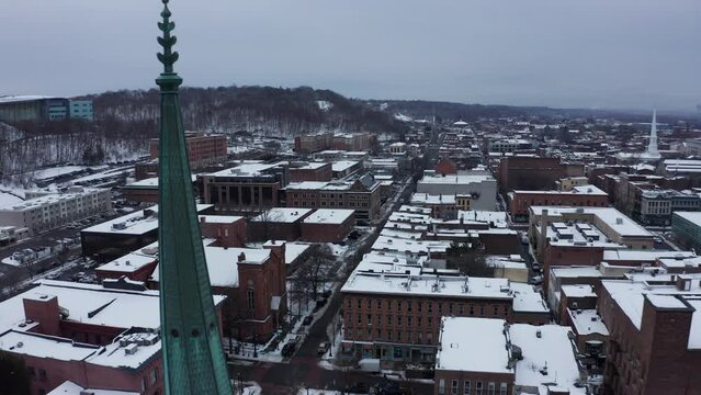 Troy, New York - aerial reveal shot of downtown and historic church steeple in winter.