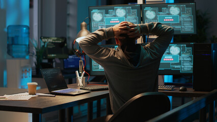 Frustrated hacker using computer to break into corporate data servers, working under pressure....