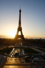 Eiffel Tower and fountains near it at dawn in Paris.