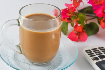 cup of cappuccino, cellphone,  and a bouquet of flowers