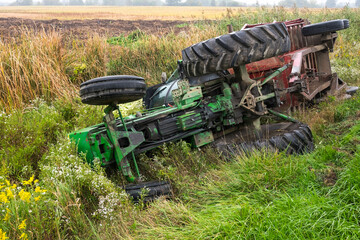 A tractor and cart from a local farm lay in a ditch after rolling off a road in Ontario Canada. - obrazy, fototapety, plakaty