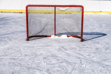 An ice hockey net torn from use sits on a rink in rural Ontario Canada.