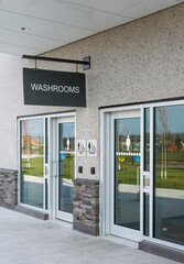 A washroom sign hangs above the entrance doors.