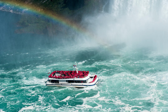 A rainbow guides a tour boat as it plies the turbulent water of the Niagara River on its way to the base of the Horseshoe Falls. Niagara Falls Canada.