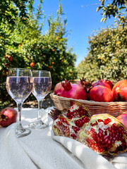 Table with pomegranates and glasses of water on farm