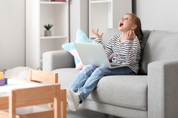 Angry little girl video chatting with psychologist on laptop at home