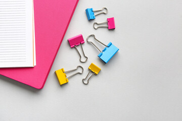 Notebooks and paper clips on light background