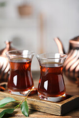 Board with cups of Turkish tea on wooden table, closeup