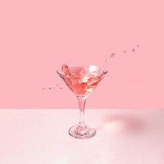 Tasty cocktail on pastel light pink background. Creative drink concept. Minimalistic beverage composition.